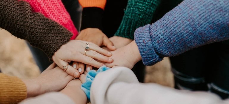 People from a support group stack their hands.