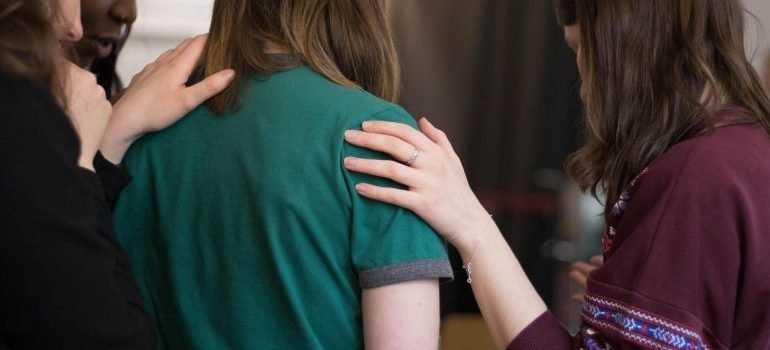 A support group consoles a person in recovery.