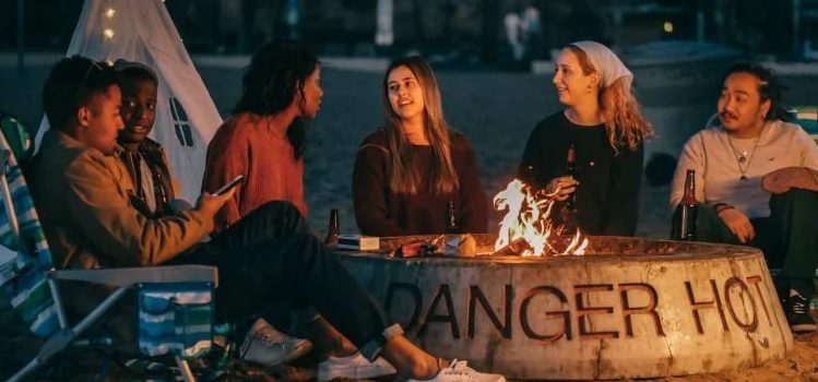 A group of people talking and drinking at the beach