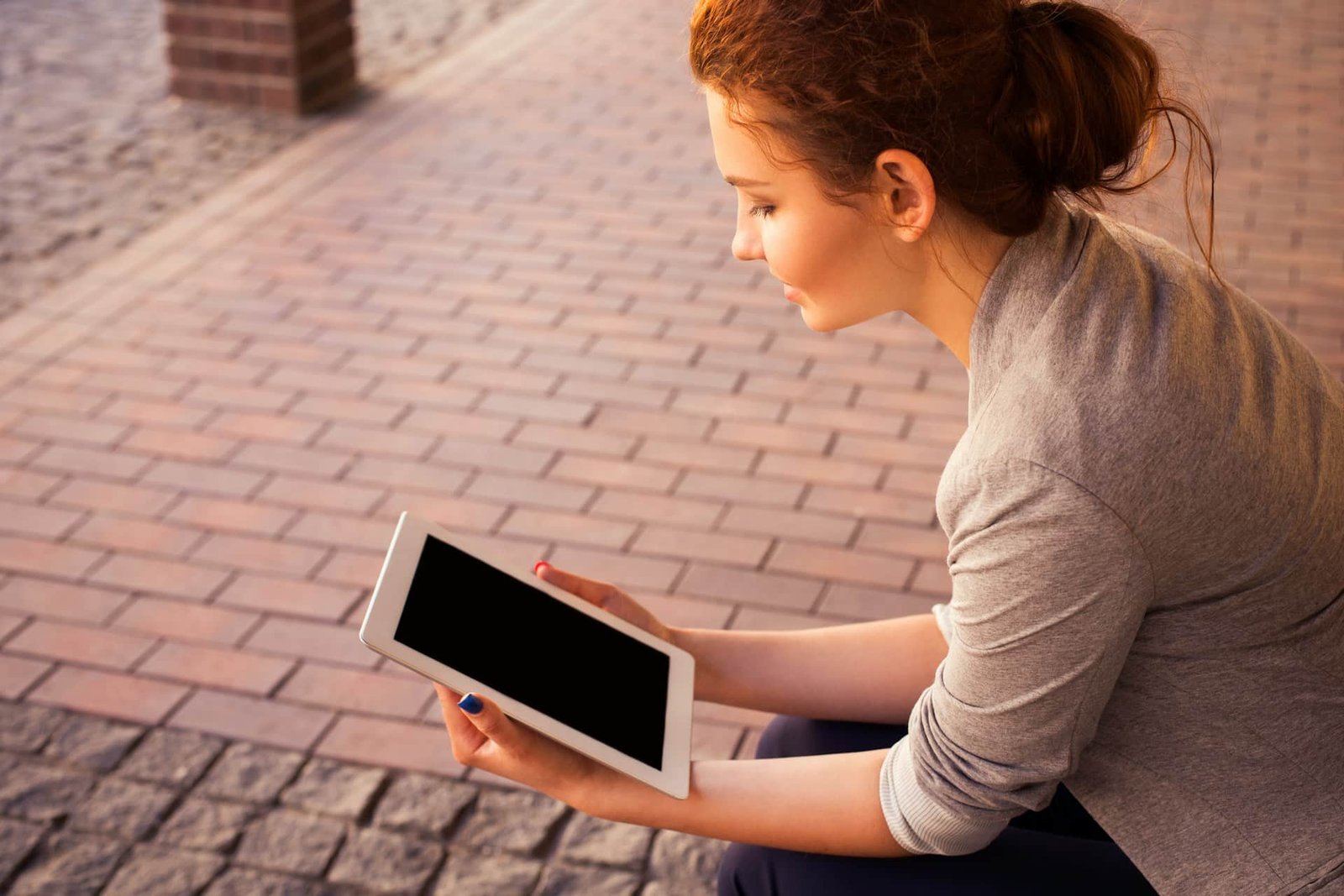 A woman is holding a white iPad and thinking of understanding relapse stages.