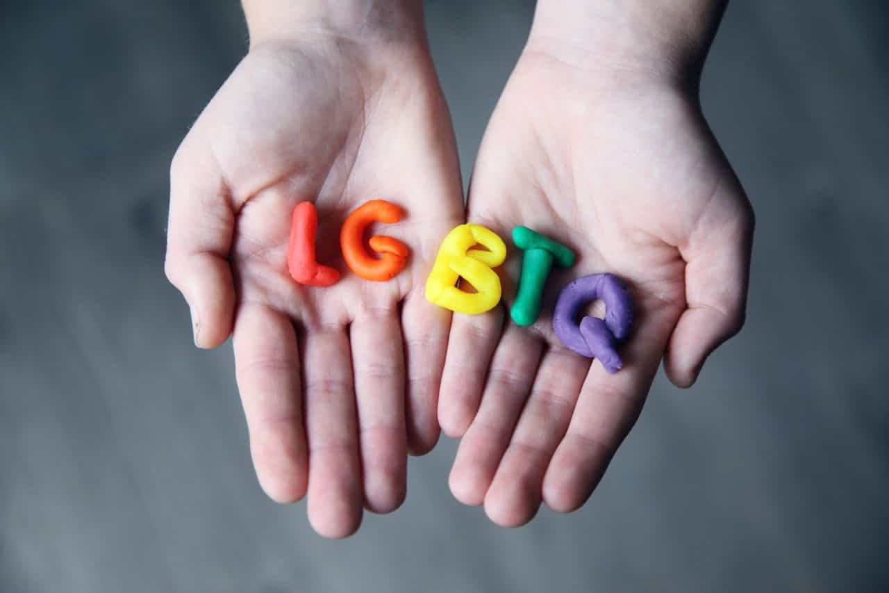 Person holding LGBTQ letters in their palms.