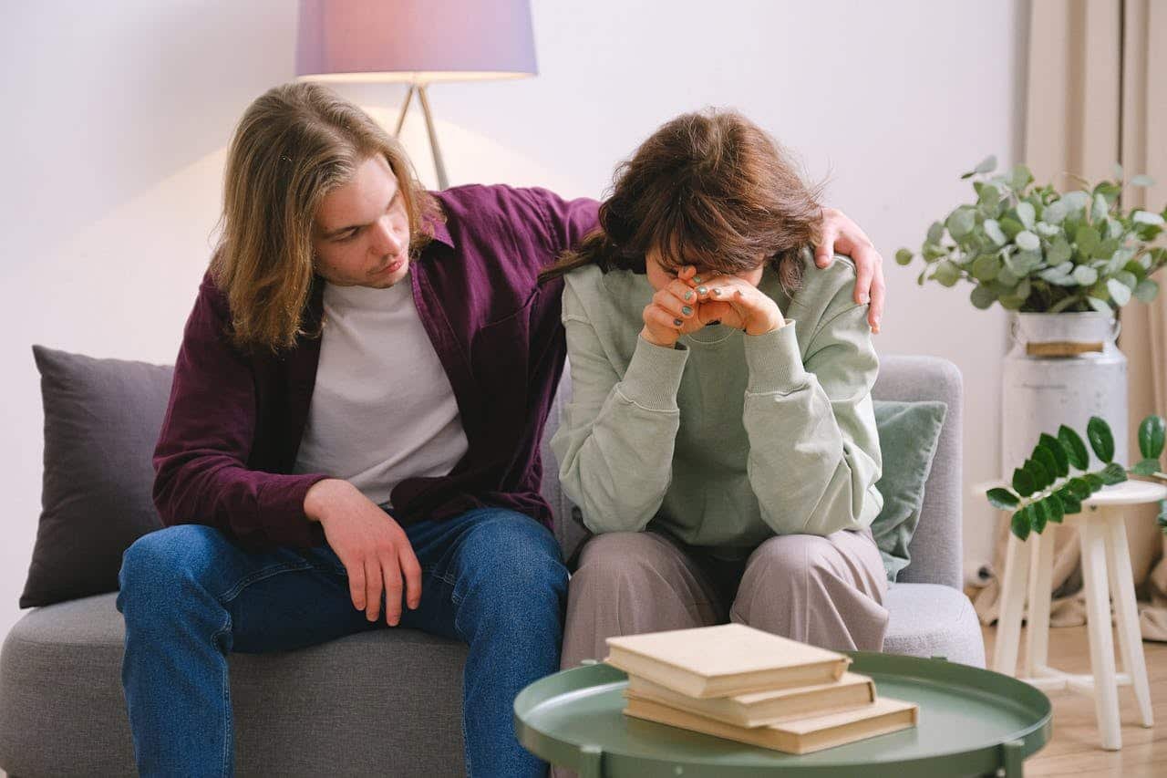 A couple being sad on a sofa symbolizes Why Do Addicts Often Blame Loved Ones?