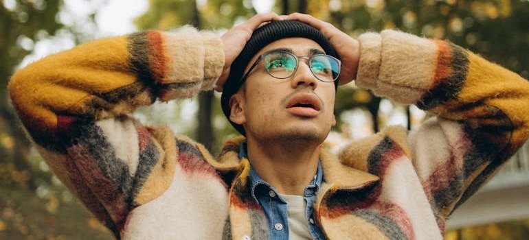 Man holding his head while experiencing anxiety, one of the hidden dangers of excessive gummy bear consumption.