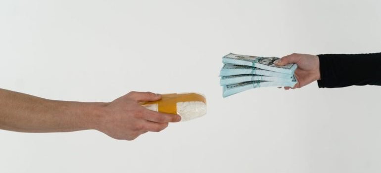 two people holding money and a package