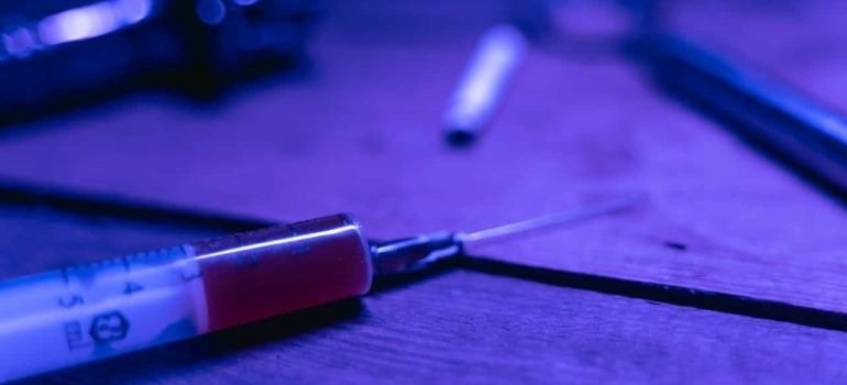 Syringe with Brown Chemical on a Wooden Table