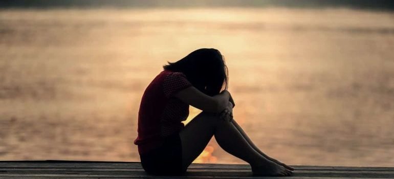 Woman Looking at Sea While Sitting on Beach