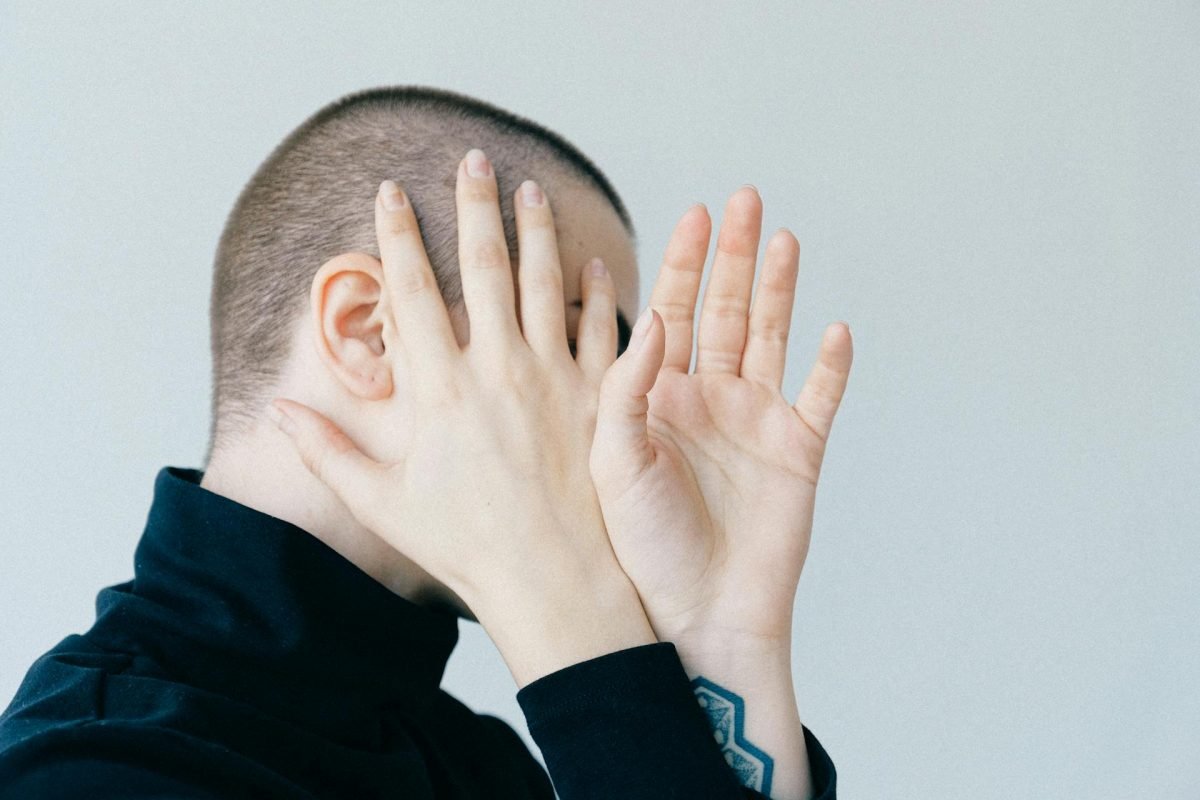 a person hiding behind hands