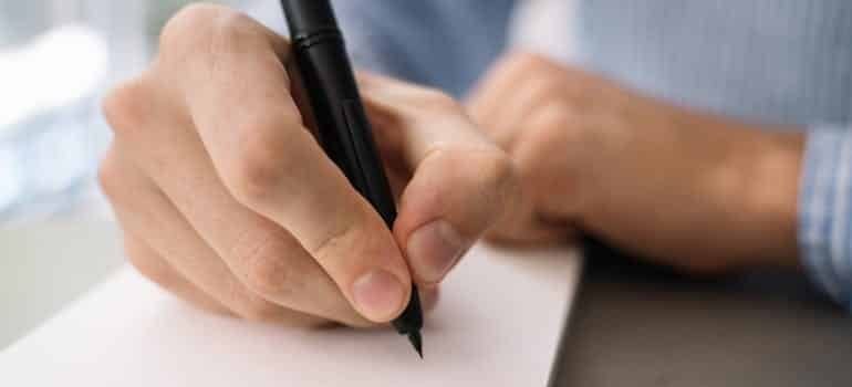 man writing in a notebook, lose custody of your child for going to rehab