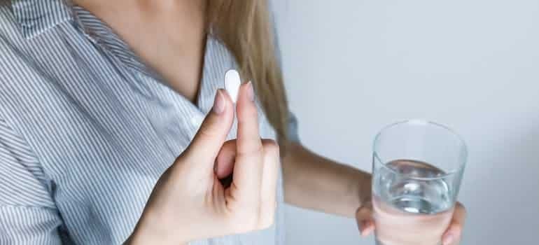 woman with pill in hand