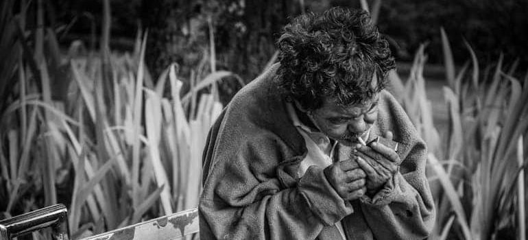 man with cigarette sitting on a bench