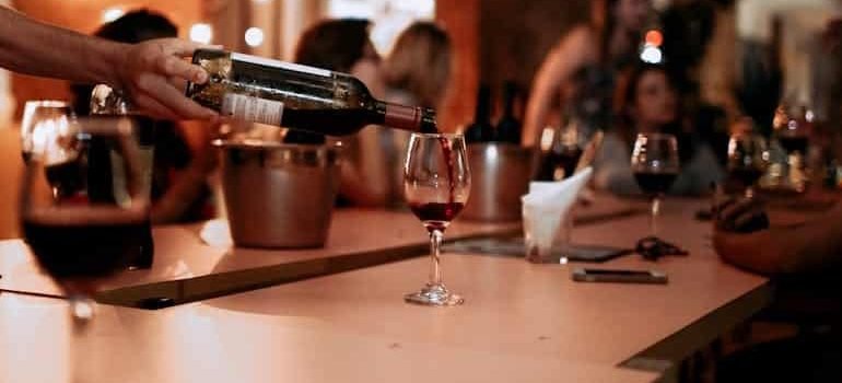 man pouring red wine in a bar